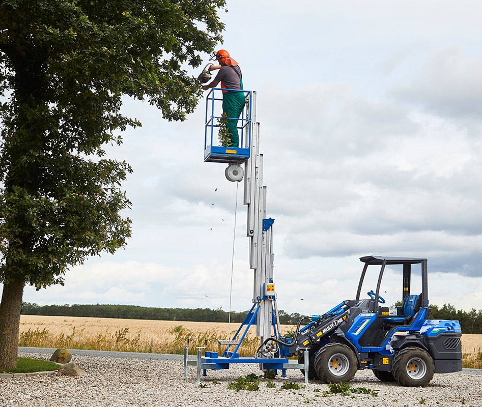man trimming a tree on an aerial platform