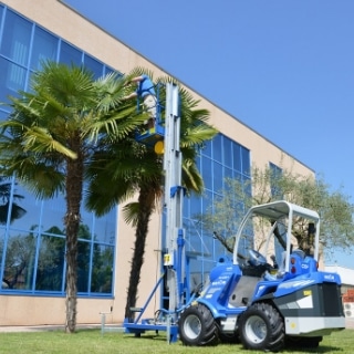 aerial work platform mounted on a mini loader to paint a building