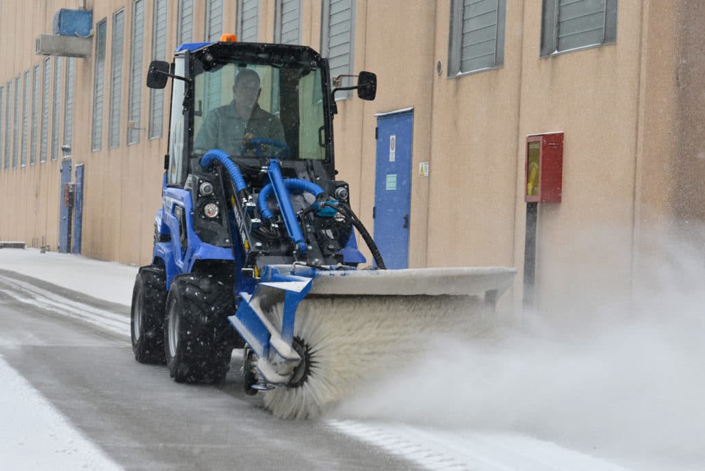 a mini loader 6 series with rotary broom attached on