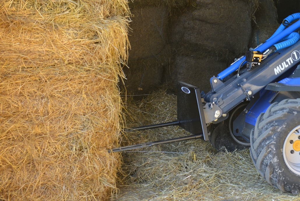 detail of a bale fork about to lift a big hay bale