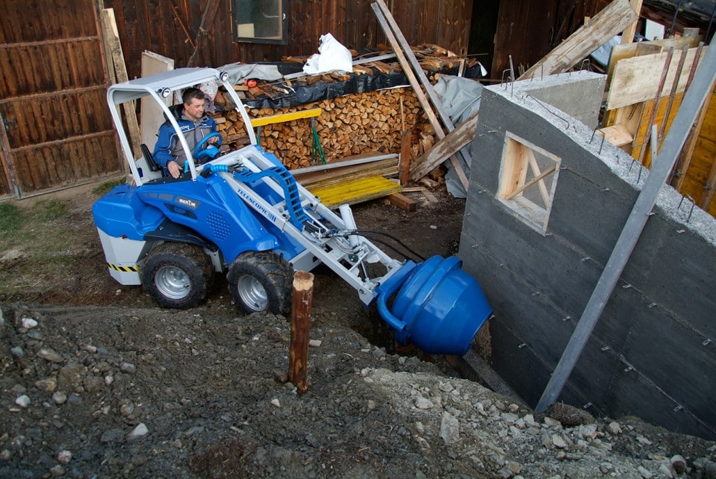 man using a cement mixer to create a building foundations