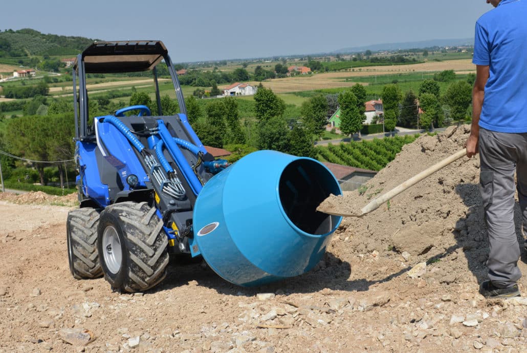 detail of a man putting soil in the cement mixer