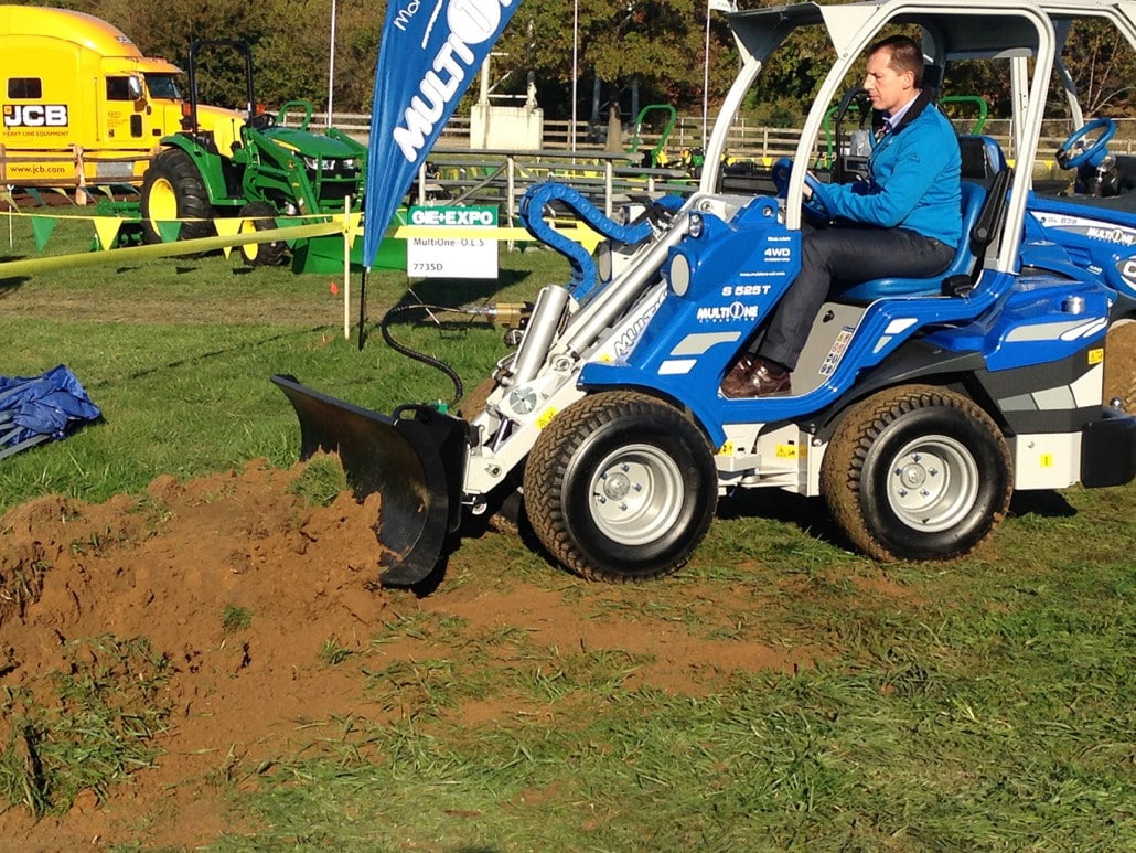 detail of a man using a dozer blade to move soil