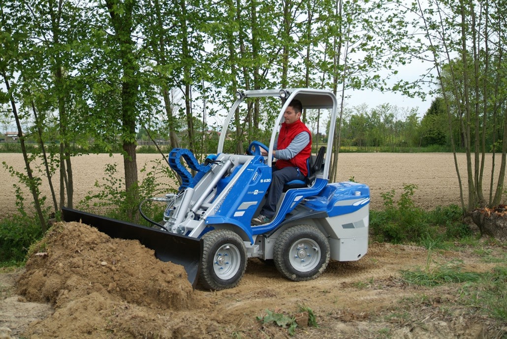 man using a dozer blade to move soil in a forest