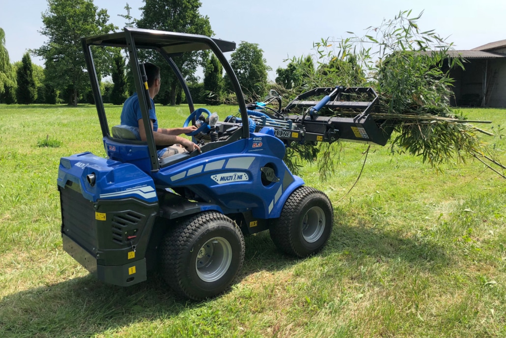 grapple bucket with lifted bucket full of tree branches