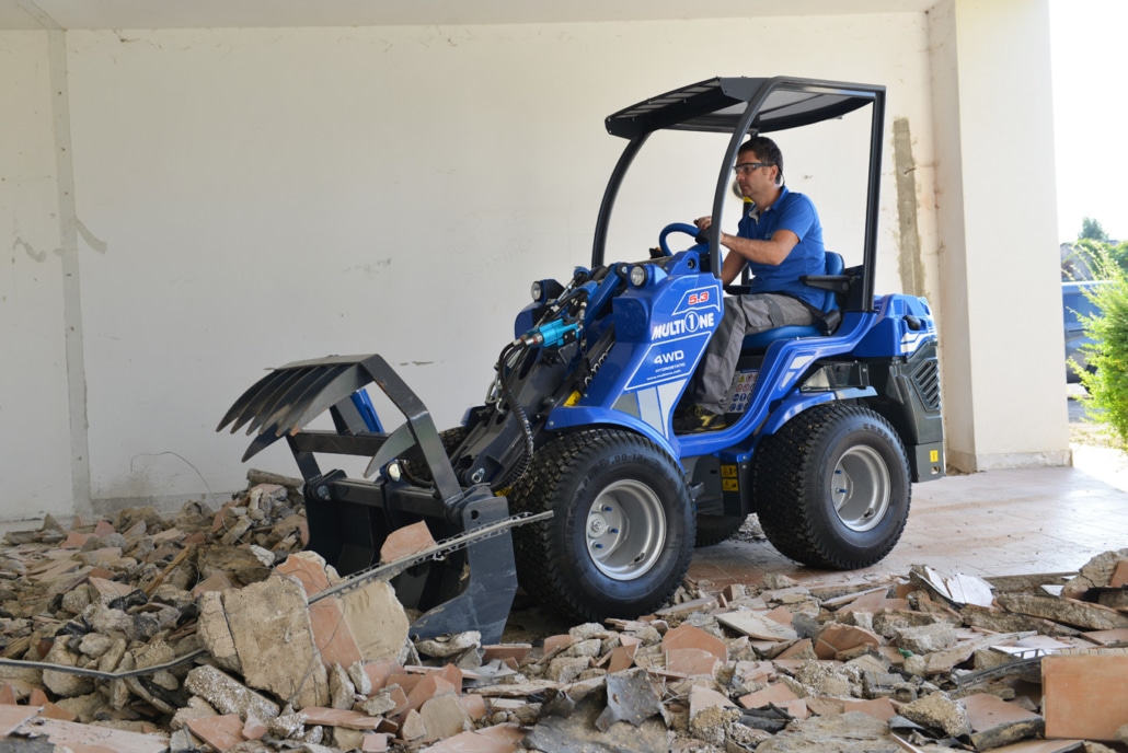 grapple bucket moving debris and tiles