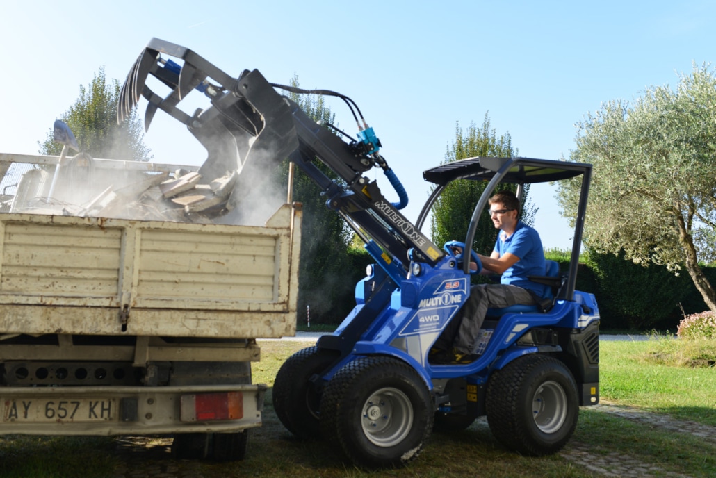 grapple bucket dropping debris in a cart