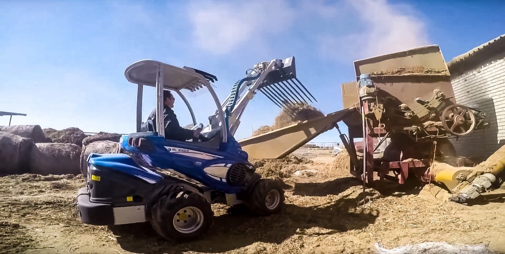 manure fork releasing hay in a bucket