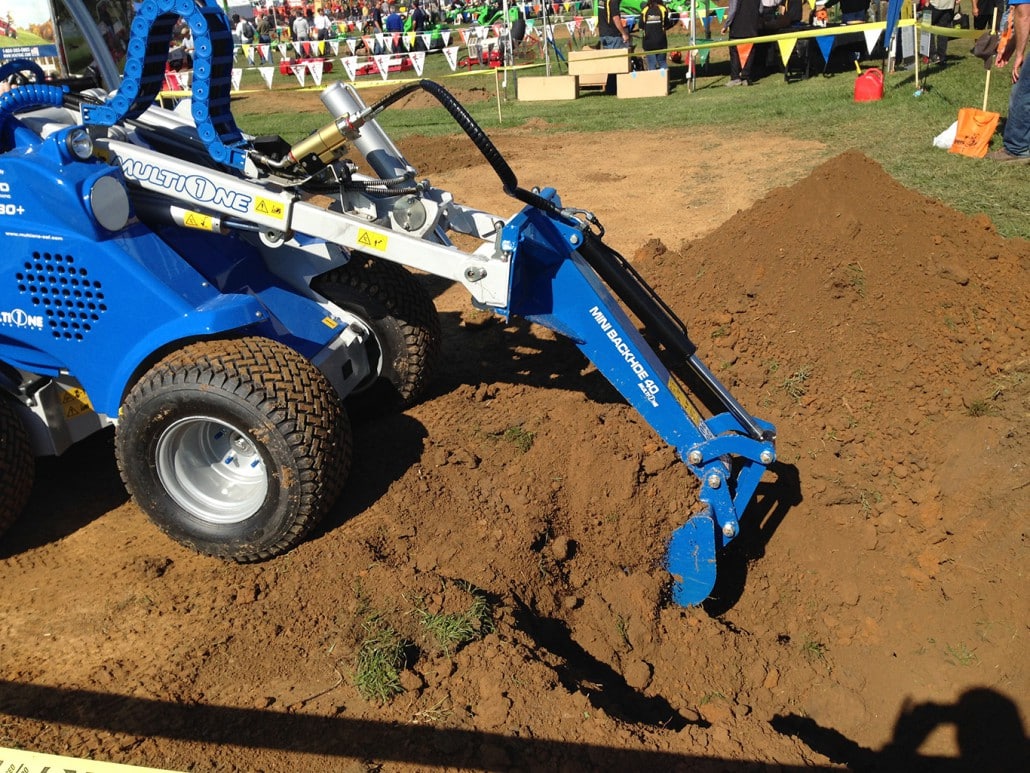 mini digger in action on a little soil mountain