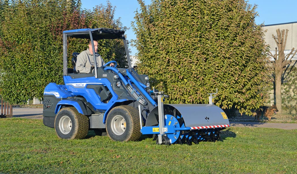 spike aerator used on a grass field during a sunny day