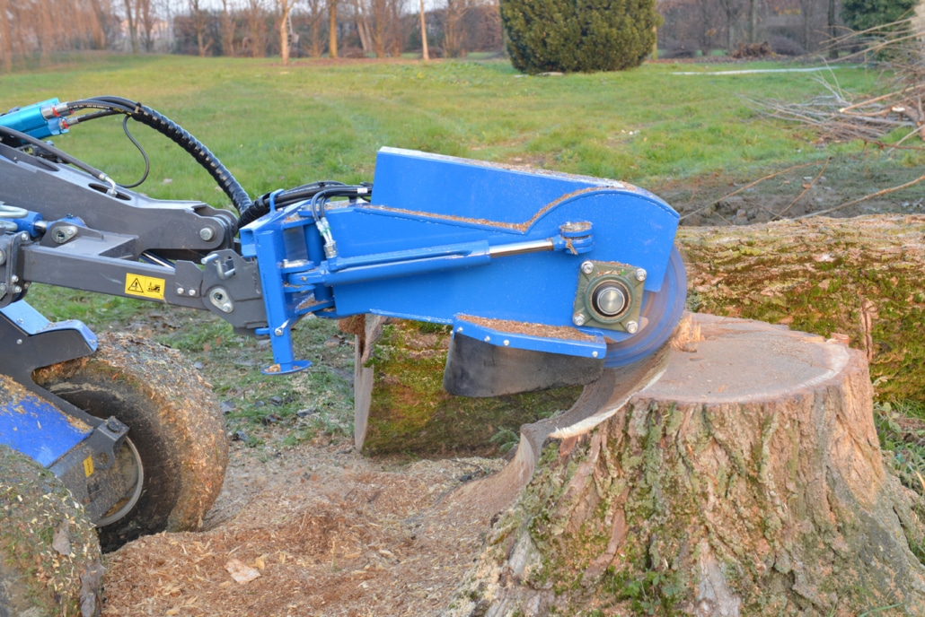 swing stump grinder cutting a log