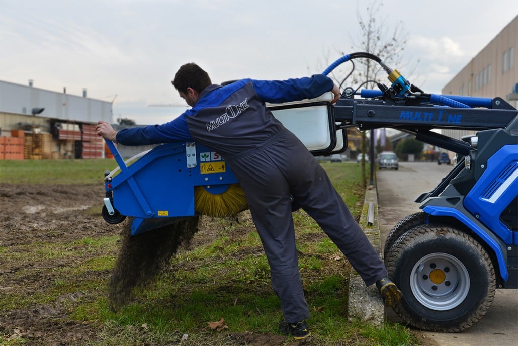 worker using a sweeper with collector