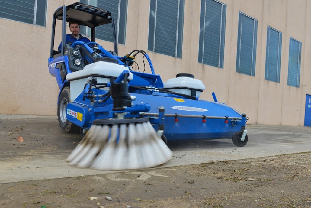 sweeper with collector in action on a sidewalk
