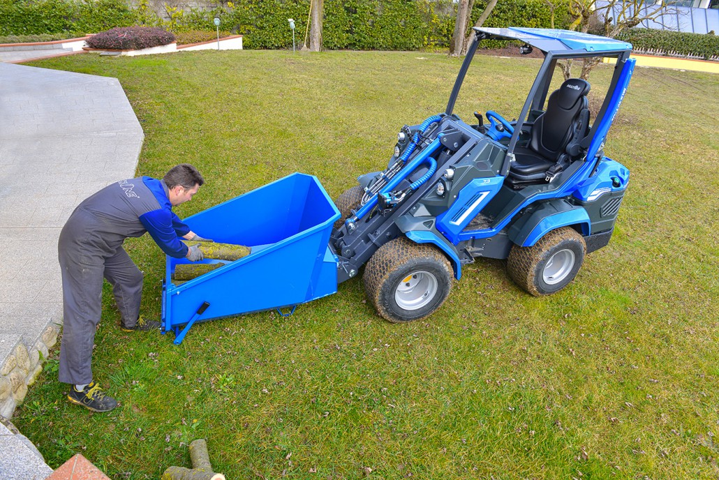 man putting wooden logs in the dumper